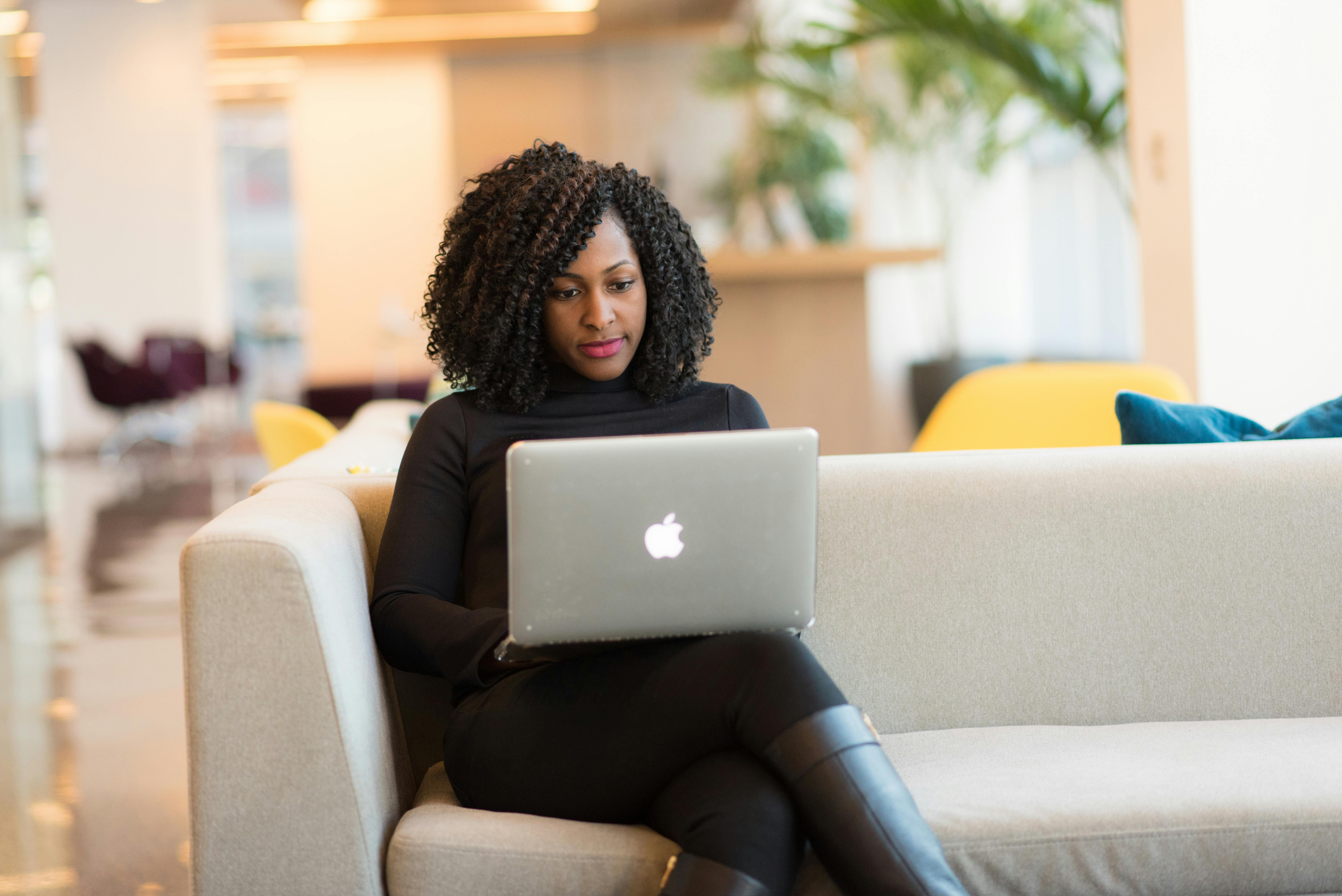 Person sitting on a couch with a laptop on thier lap